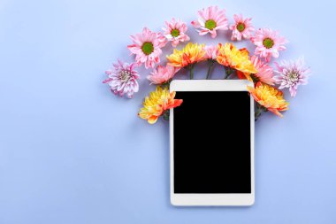 Renkli arka planda çiçeklerle modern tablet bilgisayar