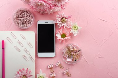 Renkli arka planda çiçek ve kırtasiye ile modern cep telefonu