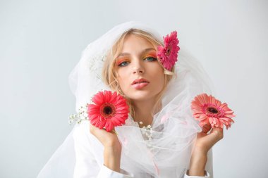 Beyaz arka planda gerbera çiçekleri ile güzel genç kadın