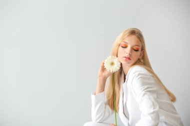 Beyaz arka plan üzerinde gerbera çiçek ile güzel genç kadın