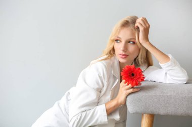 Beyaz arka plan üzerinde gerbera çiçek ile güzel genç kadın