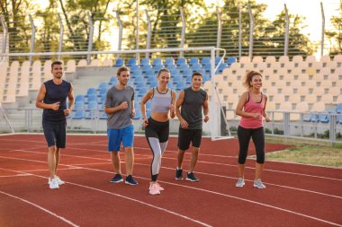 Stadyumda koşan sportif gençler