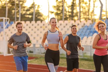 Stadyumda koşan sportif gençler