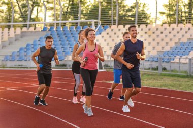 Stadyumda koşan sportif gençler