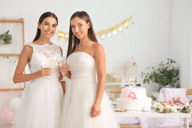 Düğün töreni sırasında şampanya bardak ile güzel lezbiyen çift