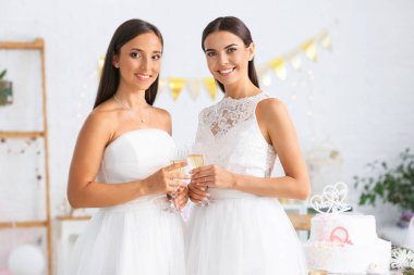 Düğün töreni sırasında şampanya bardak ile güzel lezbiyen çift