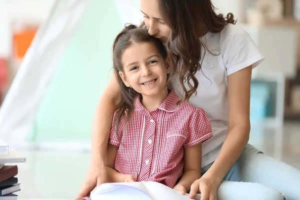 Schattig klein meisje en haar oudere zus lezen boek thuis — Stockfoto