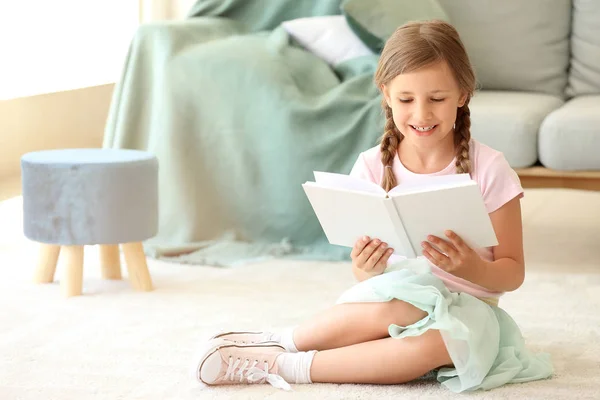 Linda niña leyendo libro en casa — Foto de Stock