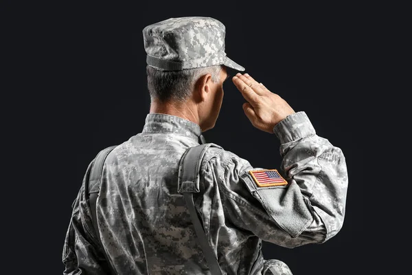 Saluting male soldier on dark background — Stock Photo, Image