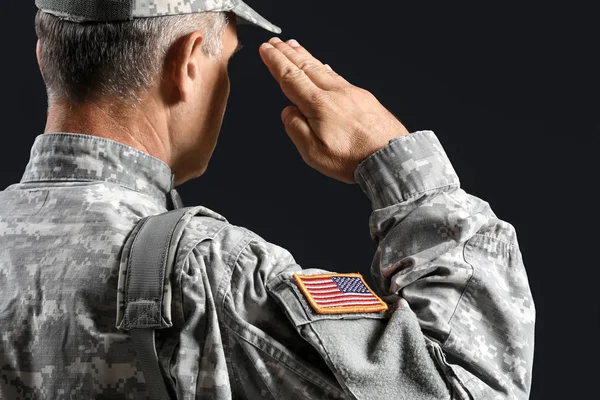 Salutings manliga soldat på mörk bakgrund — Stockfoto