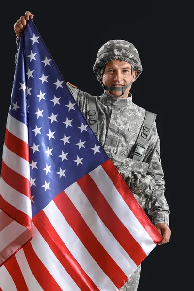 Gammal manlig soldat med USA flagga på mörk bakgrund — Stockfoto