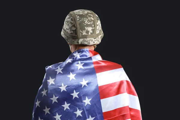 Gammal manlig soldat med USA flagga på mörk bakgrund, back View — Stockfoto