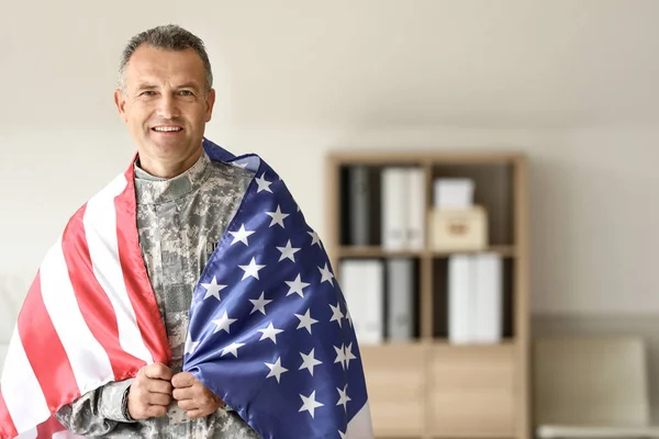 Mature male soldier with USA flag in headquarters building — Stock Photo, Image