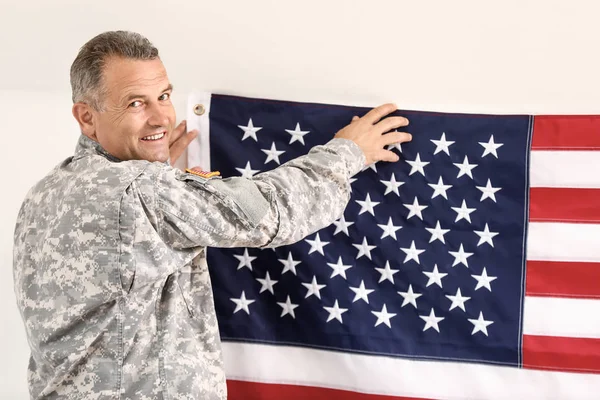 Mogna manliga soldat hängande USA flagga på väggen i högkvarter byggnad — Stockfoto