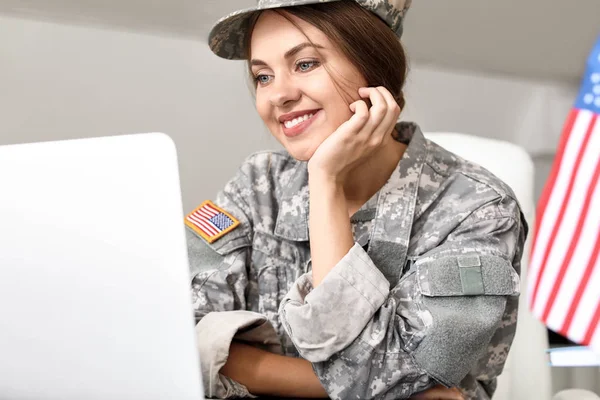 Karargah binasında dizüstü bilgisayarla çalışan genç kadın asker — Stok fotoğraf