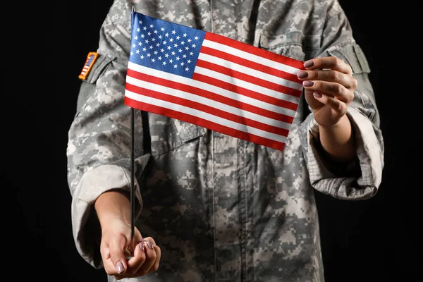 Ung kvinnlig soldat med USA flagga på mörk bakgrund — Stockfoto