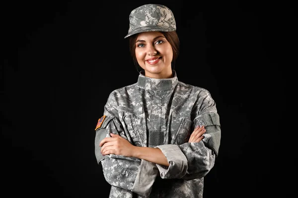 Ung kvinnlig soldat på mörk bakgrund — Stockfoto