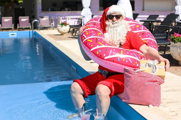 Papai Noel com anel inflável perto da piscina no resort — Fotografia de Stock
