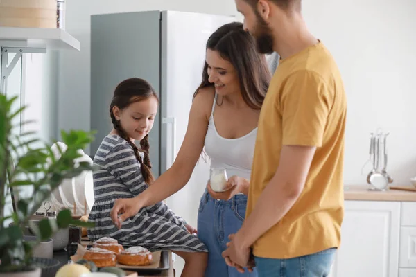 Familia joven con bollos recién horneados en la cocina — Foto de Stock