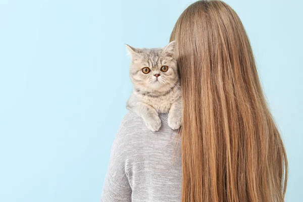 Beautiful young woman with cute cat on color background — Stock Photo, Image