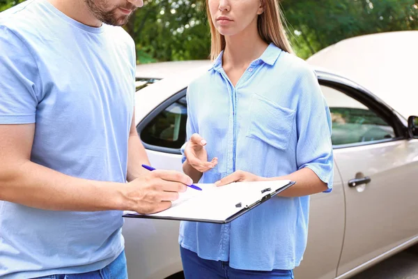 Conductor y agente de seguros cerca de coche dañado al aire libre — Foto de Stock