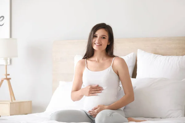 Hermosa joven embarazada en el dormitorio — Foto de Stock