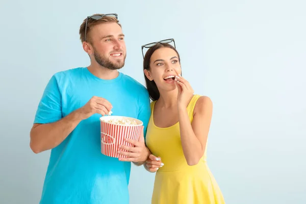 Νεαρό ζευγάρι με ποπκόρν βλέποντας ταινία σε φως φόντο — Φωτογραφία Αρχείου