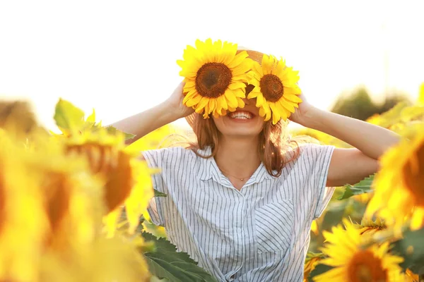 Beautiful young woman in sunflower field on summer day — Stock Photo, Image