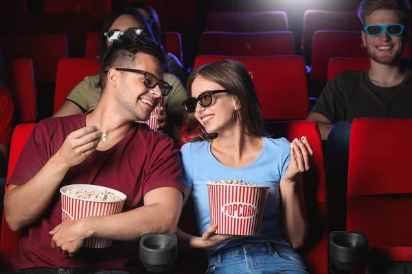 Couple with popcorn watching movie in cinema