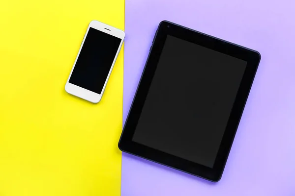Modern tablet computer with mobile phone on color background — Stock Photo, Image