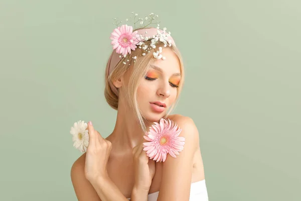 Beautiful young woman with flowers on color background — Stock Photo, Image