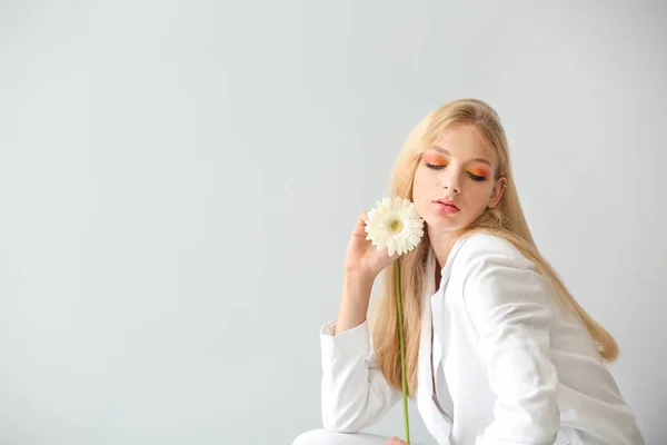 Beautiful young woman with gerbera flower on white background — Stock Photo, Image