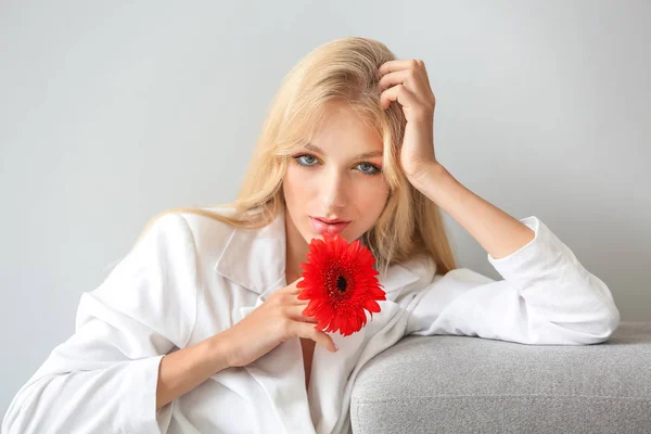 Vacker ung kvinna med Gerbera blomma på vit bakgrund — Stockfoto