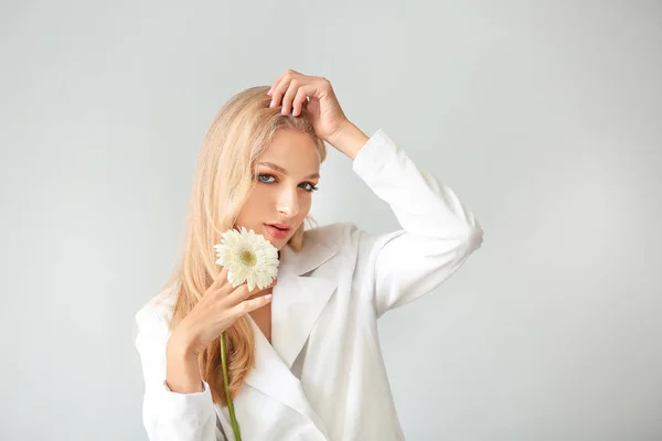 Красива молода жінка з квіткою гербери на білому тлі — стокове фото