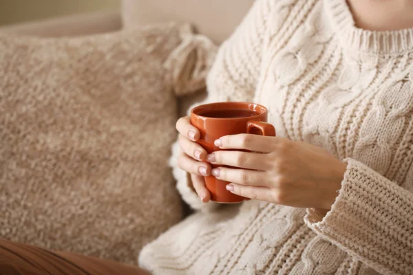 Mujer joven bebiendo té caliente en casa, primer plano — Foto de Stock