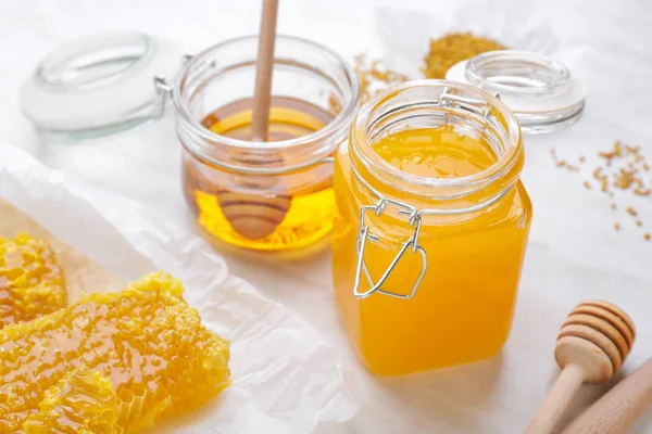 Jars of sweet honey and combs on table — Stock Photo, Image