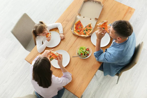 Familia feliz comiendo pizza en casa — Foto de Stock