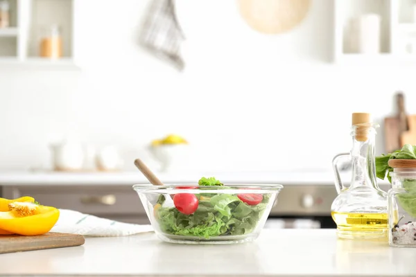 Ciotola con gustosa insalata sul tavolo della cucina — Foto Stock