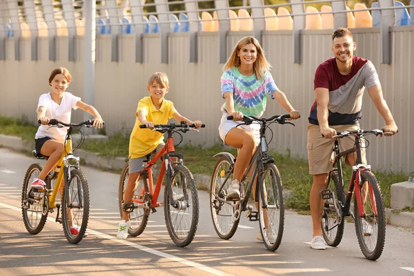 Happy family riding bicycles outdoors
