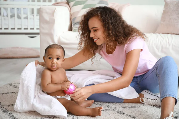 Young African-American mother with cute baby after bathing at home — Stock Photo, Image