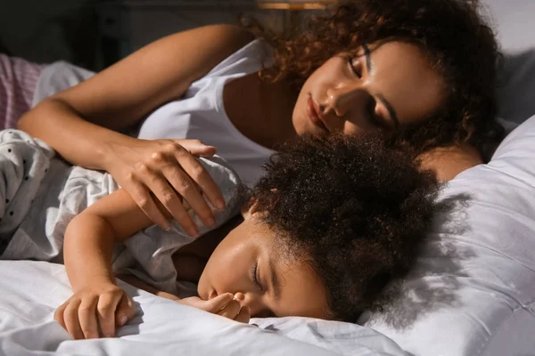 Little African-American girl with mother sleeping in bed at night — Stock Photo, Image
