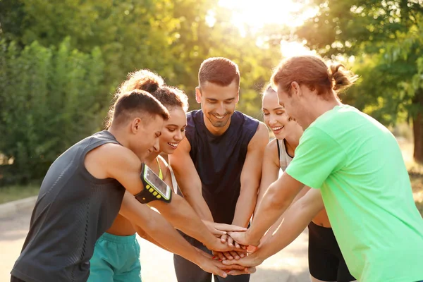 Dışarıda el ele tutuşan sportif gençler grubu — Stok fotoğraf