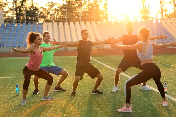 Group of sporty young people training at the stadium — Stock Photo, Image
