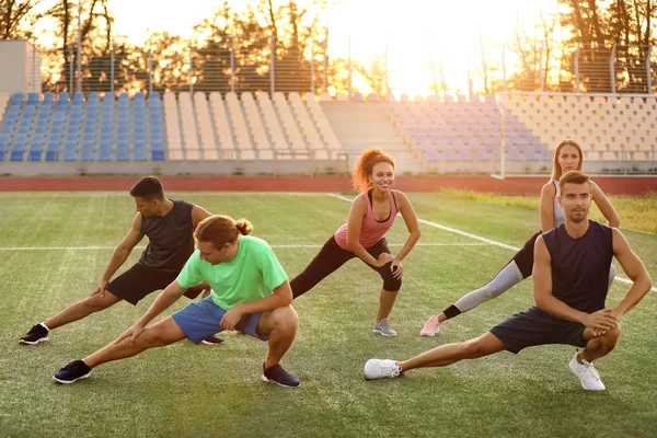 Group of sporty young people training at the stadium — Stock Photo, Image