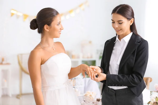 Jovem casal lésbico trocando anéis durante a cerimônia de casamento — Fotografia de Stock