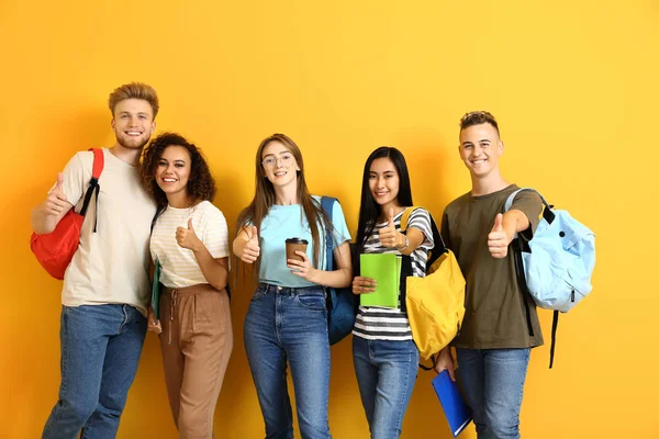 色の背景に親指のジェスチャーを表示する学生のグループ — ストック写真