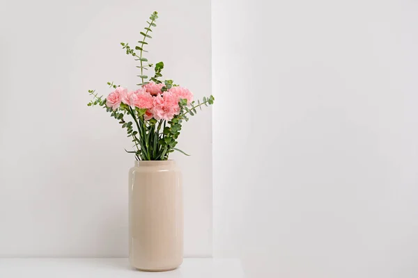 Vase with beautiful carnation flowers on light table — Stock Photo, Image