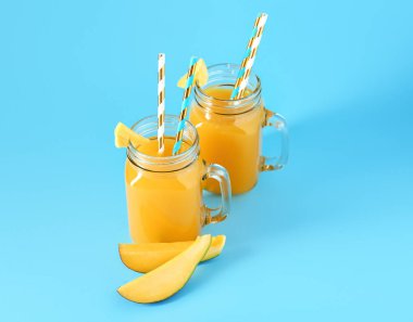 Renk arka plan üzerinde taze mango suyu Mason kavanoz