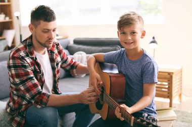 Baba evde gitar çalmayı küçük oğlu öğretim
