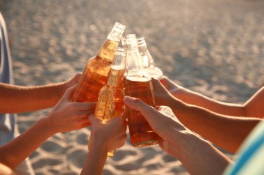 Arkadaşlar deniz plajında bira içiyor
